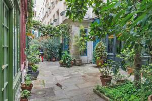a courtyard with potted plants in a building at Le Passage Du Marais in Paris