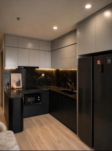 a kitchen with black cabinets and a black refrigerator at Ocean Nest - 2BR Apartment in Ocean Park in Gia Lâm Pho