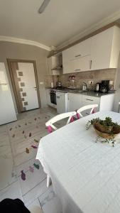 a kitchen with a white table and chairs and a table and a kitchen at Peribacası Manzaralı Modern Daire 2 in Ürgüp