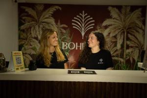two women are sitting at a counter talking at Bohemia Boutique Hostel in Cali +75 photos
