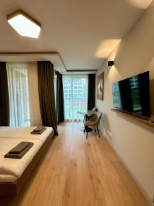 a bedroom with a bed and a desk and a television at Eleve Residences - Sand Studio in Sofia