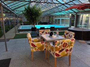 a table and chairs in a patio with a pool at Köpingebro in Köpingebro