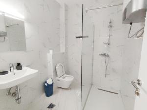 a white bathroom with a shower and a toilet at Hotel Han Gusinje in Gusinje +54 photos