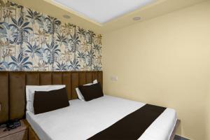 a bedroom with a bed and a wall with a wallpaper at Super Hotel O RS PALACE in Jhānsi +23 photos