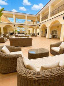 a patio with wicker chairs and couches in a building at Casa Azul, with a shared pool in Baños y Mendigo