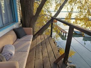 a couch sitting on a porch next to a tree at The Marina Treehouse in Hamuliakovo