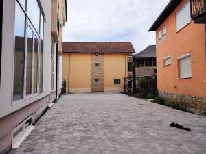 an alley between two buildings with a cat laying on the ground at Hotel Han Gusinje in Gusinje