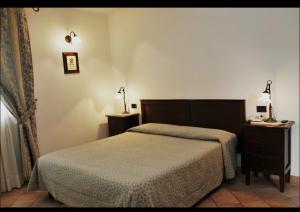 a bedroom with two beds and a table and a lamp at hotel il ghiro in Ovindoli