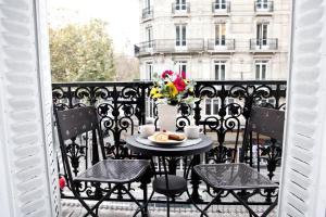 a table with a plate of food on a balcony at La Charme Du Marais in Paris