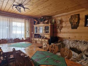 a dining room with a wooden table and chairs at U Bobaków in Murzasichle