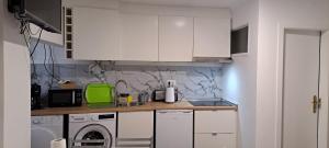 a kitchen with white cabinets and a washing machine at Elvasguesthouse in Elvas +8 photos