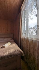 a small bedroom with a bed and a window at Guesthouse Marshan in Ushguli