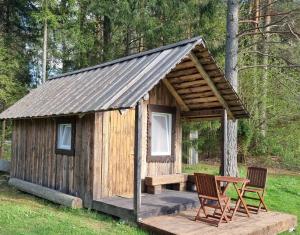 a wooden cabin with two chairs and a table at Oandu Camping in Oandu