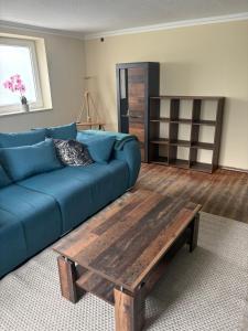 a living room with a blue couch and a wooden coffee table at FeWo Johann Friedrich in Hilpoltstein