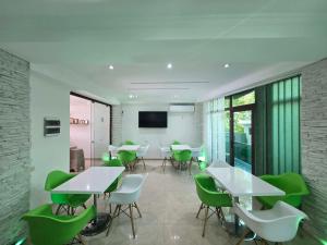a dining room with tables and green chairs at Green House in Ureki