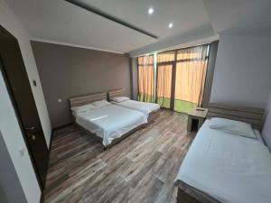 a bedroom with two beds and a large window at Green House in Ureki