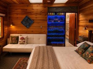 a bedroom with a white couch and a large glass window at Chalet Magico en el Bosque in Oicatá