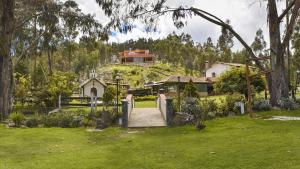 a house sitting on top of a lush green field at Chalet Magico en el Bosque in Oicatá