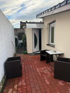 a patio with a table and chairs next to a building at Sirine57 Charming House for 5 Guests Large Private Parking for Cars Vans in Florange