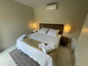 a bedroom with a bed with white sheets and pillows at Beco do Mar Cumbuco in Cumbuco +57 photos