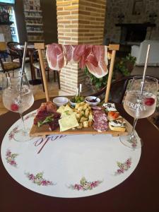 a plate of food with meat and two glasses of wine at hotel il ghiro in Ovindoli +6 photos