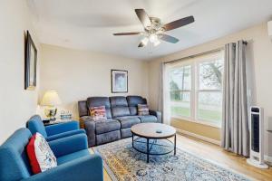a living room with a blue couch and a ceiling fan at Champ's Camp in Colchester