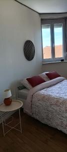 a bedroom with a bed and a table and a window at Maison Aux Cailloux in Calais