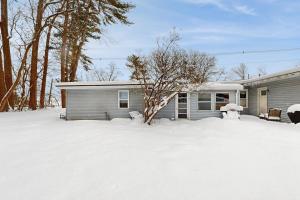 a house with a snow covered yard in front of it at Champ's Camp in Colchester