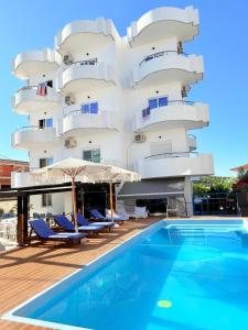 a hotel with a swimming pool in front of a building at Hotel Belle Vue in Ksamil