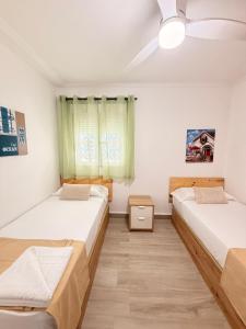 a bedroom with two beds and a window at Brisas del mar in Faro de Cullera