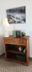 a wooden dresser with a lamp on top of it at Maison Aux Cailloux in Calais +26 photos
