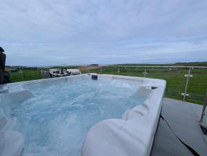 a hot tub on a deck with a view of a field at 3 Bed in Girvan oc-96394 in Girvan
