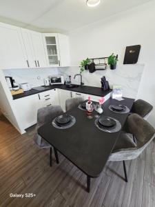 a kitchen with a black table and chairs in a room at Ferienwohnung Molly inclusive Hallenbad, Sauna, Fitnessstudio und Aussenpool in Sankt Englmar