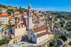 an aerial view of a city with a clock tower at Stone house Sprtini-Brač in Ložišće