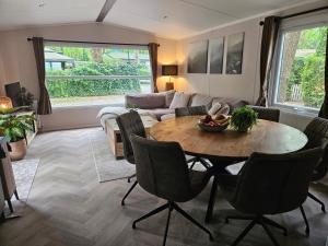 ein Wohnzimmer mit einem Tisch und einem Sofa in der Unterkunft Roosje in Hoenderloo