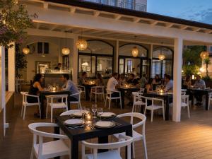 a group of people sitting at tables in a restaurant at Primo Hotel in Marciana Marina