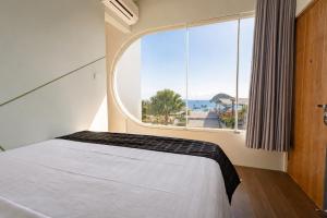 a bedroom with a bed and a large window at Inn Room Hotel Bajo in Labuan Bajo +47 photos