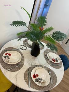 a white table with plates and utensils on it at Laurier-Rose Gîte in Châteaudun