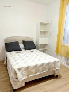 a bed in a white room with a white bed sidx sidx sidx at Laurier-Rose Gîte in Châteaudun