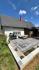 a house with a patio with a table and benches at Chalupa Abecha in Dolní Poustevna