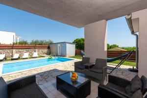 a villa with a swimming pool and a hammock at Holiday Home Casa Vida in Rakalj