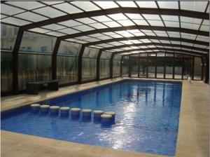 a large swimming pool with a retractable roof at Duplex Playa Rapadoira con piscina in Foz