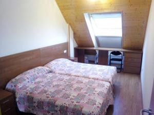a small bedroom with a bed and a desk at Duplex Playa Rapadoira con piscina in Foz +6 photos