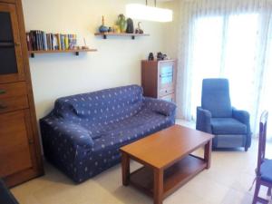 a living room with a couch and a chair and a table at Duplex Playa Rapadoira con piscina in Foz