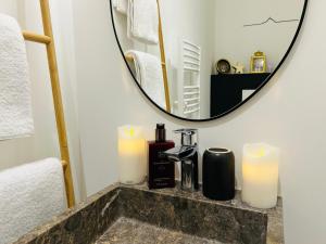 Ein Waschbecken im Badezimmer mit zwei Kerzen und einem Spiegel in der Unterkunft Maison Bailly in Ducey + 54 Fotos