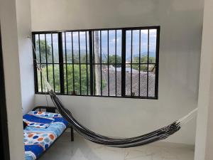 a room with a hammock in front of a window at Casa Armonia in Honda +15 photos