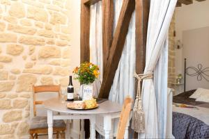 uma mesa com uma garrafa de vinho e um prato de queijo em Le Diamant En Isle em Paris