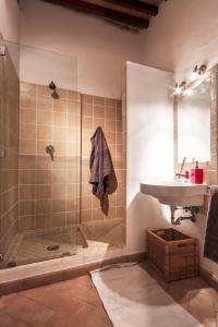 ein Bad mit einer Dusche und einem Waschbecken in der Unterkunft Da Leo in Montefollonico