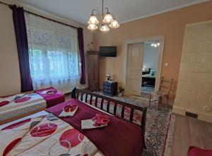 a bedroom with two beds and a chandelier at Vazsita ház in Erdőbénye