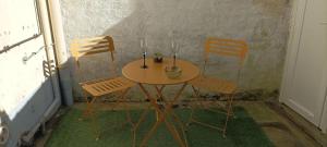 a table with two chairs and a table with two candles at Maison Aux Cailloux in Calais